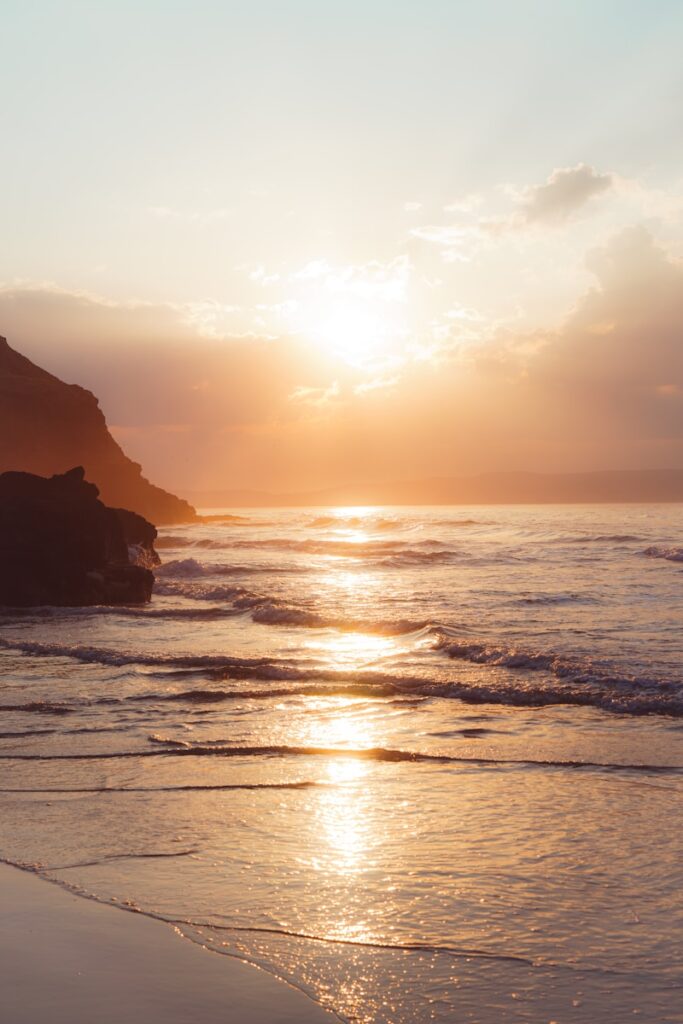 Sunset glistens over the ocean and the beach.